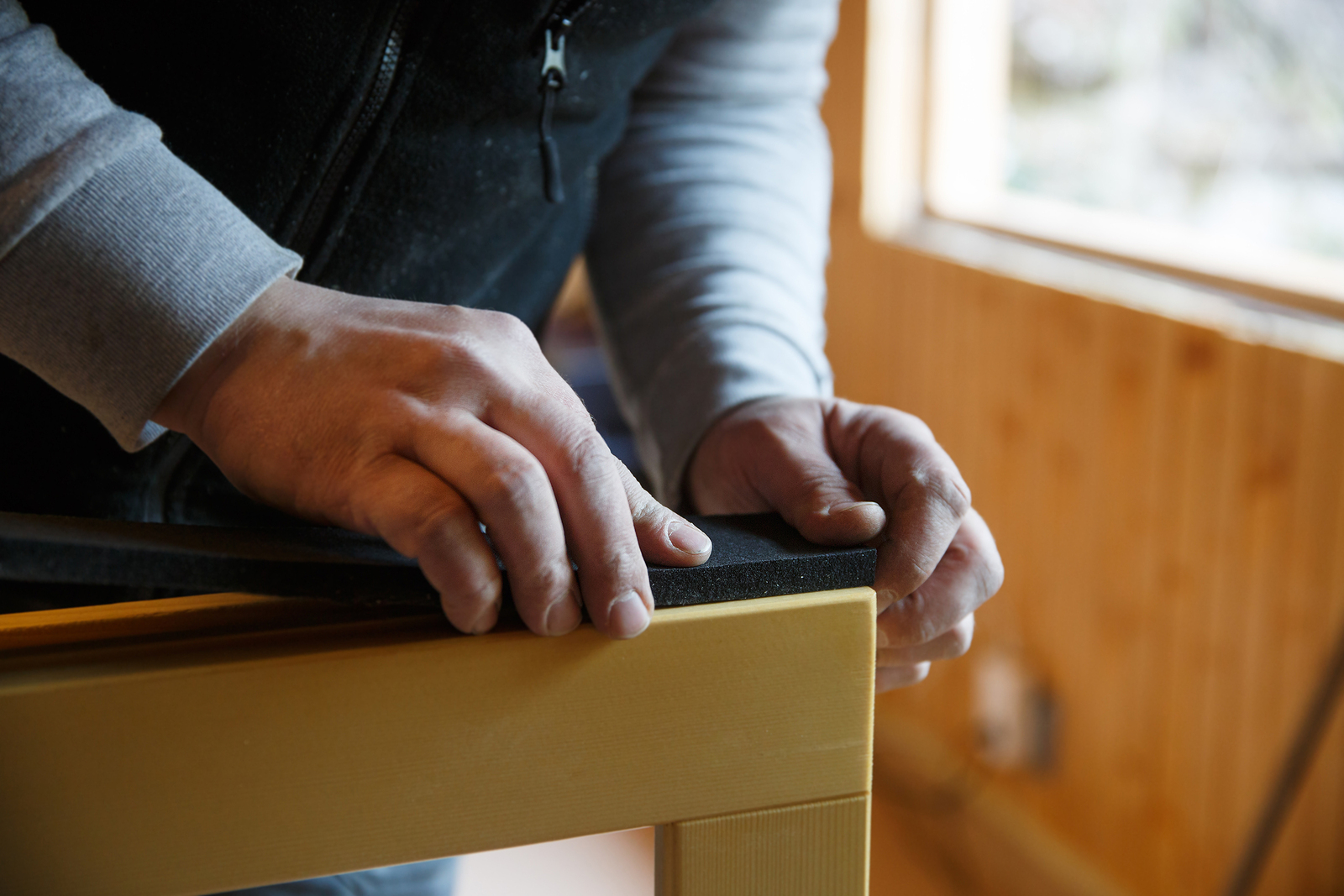 Custom Replacement Windows for Asymmetrical Openings in Contemporary Homes, Worker preparing to install new three pane wooden windows in an old wooden house. Home renovation sustainable living energy efficiency concept.