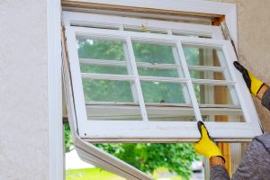 How often should windows and doors be replaced, Worker hand removing old window replacing the old wooden window,